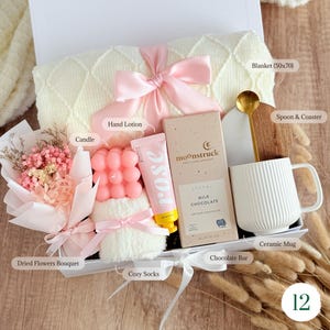 Thoughtful gift box for her with dried flower bouquet, candle, hand 
cream, ceramic mug, and gold spoon — care package gift for women