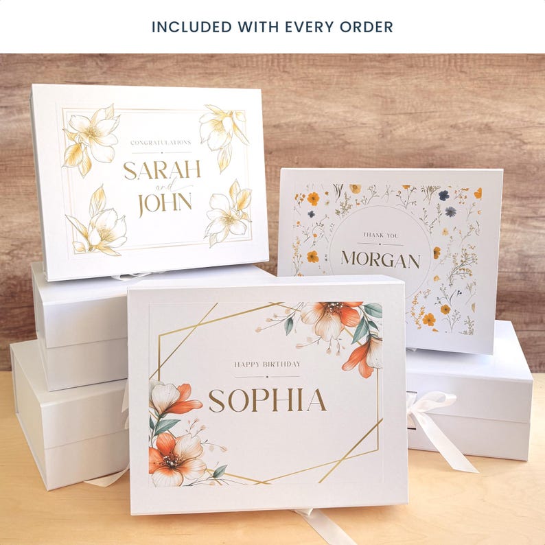 May include: White gift boxes with floral designs and text. One box reads "Sarah and John" with floral accents. Another says "Morgan" with a floral border. A third box says "Sophia" with orange flowers and a gold geometric frame.