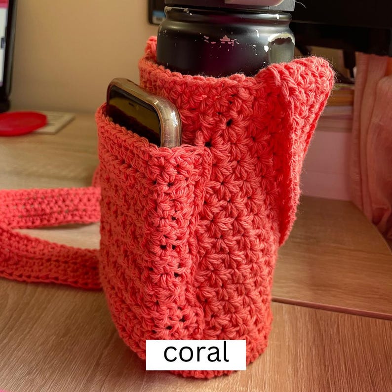 May include: Coral crocheted bag with a pocket for a phone and a strap. The bag is designed to hold a water bottle.