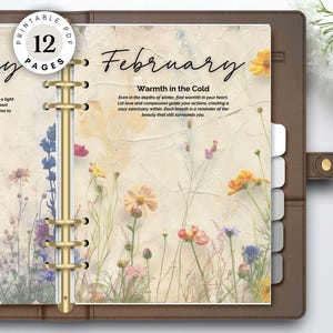 Op de afbeelding: Een bruine leren planner met gouden ringen, open op pagina's met bloemenillustraties en tekst. Op de linkerpagina staat "January Beginnings" en op de rechterpagina "February Warmth in the Cold". Een ronde sticker luidt "PRINTABLE PDF 12 PAGES".
