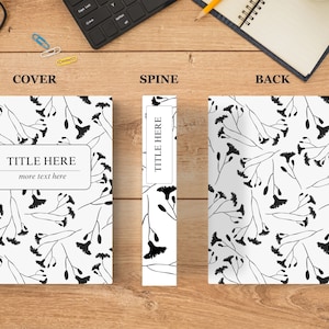 May include: A black and white book cover with a floral pattern and the text "TITLE HERE" and "more text here". The spine of the book has the text "TITLE HERE" in black text on a white background. The back cover of the book has the same floral pattern as the front cover.