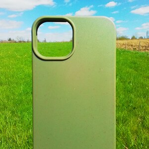 Op de afbeelding: Een groene telefoonhoes met een uitsparing voor de camera. De hoes is gemaakt van een getextureerd materiaal en heeft een matte afwerking.