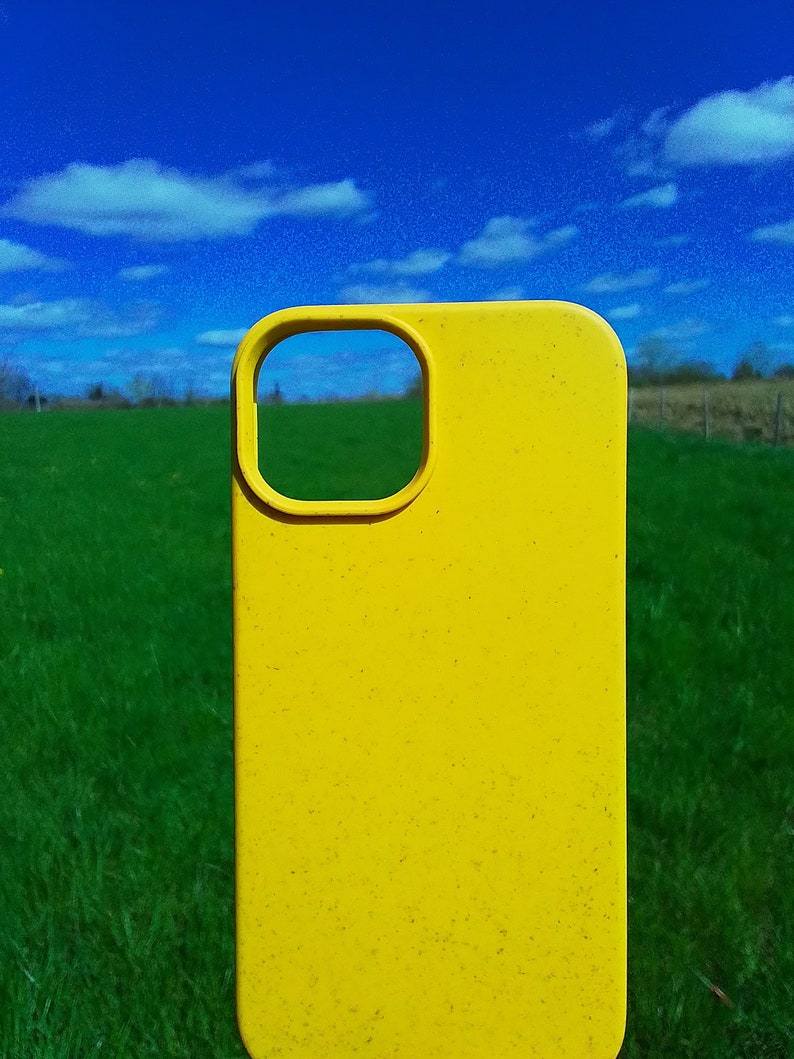 Op de afbeelding: Een felgele telefoonhoes met een uitsparing voor de camera. De hoes is gemaakt van een getextureerd materiaal en heeft een licht verweerde uitstraling.