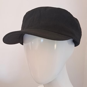 May include: A black baseball cap with a curved peak. The cap is made from a dark, soft material and is displayed on a white mannequin head. The design is simple and classic, suitable for everyday wear.