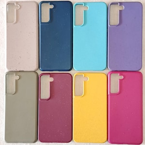 May include: Eight mobile phone cases in a variety of colours: beige, navy, turquoise, purple, olive green, burgundy, yellow, and magenta. Each case is rectangular with rounded corners and a camera aperture.