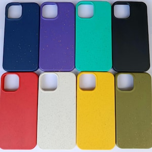 Könnte beinhalten: Eine Sammlung von acht farbenfrohen Handyhüllen. Die Hüllen sind in verschiedenen Farben erhältlich, darunter Marineblau, Lila, Grün, Schwarz, Rot, Off-White, Gelb und Olivgrün. Jede Hülle hat einen Kameraausschnitt und eine gesprenkelte Textur.