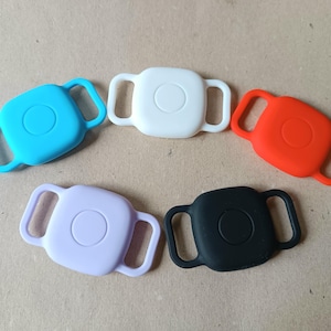 May include: Five silicone adjustable straps in different colours: light blue, white, red, lavender, and black. Each strap has a round button in the centre.