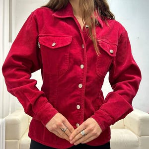 Puede incluir: Una camisa de pana roja con botones, mangas largas y silueta ajustada.