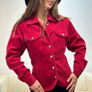 Puede incluir: Una camisa de pana roja con botones, mangas largas y dos bolsillos en el pecho.