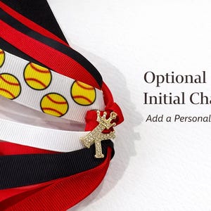 May include: A collection of ribbons in red, black, and white, with a softball design. A gold-colored initial charm is attached. The text "Optional Initial Charm, Add a Personal Touch" is also visible.