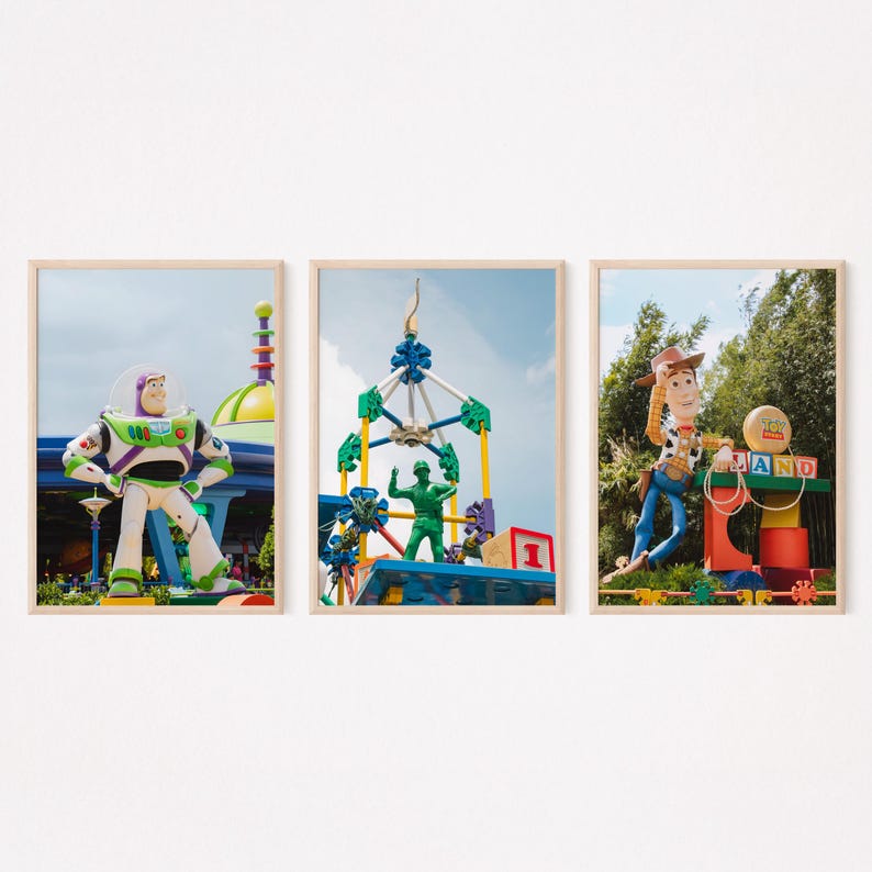 Puede incluir: Tres impresiones enmarcadas con personajes de la franquicia Toy Story. La primera impresi&oacute;n muestra a Buzz Lightyear de pie frente a un edificio futurista colorido. La segunda impresi&oacute;n muestra a un hombre verde del ej&eacute;rcito de pie sobre una estructura colorida hecha de bloques de construcci&oacute;n. La tercera impresi&oacute;n muestra a Woody, el mu&ntilde;eco vaquero, de pie frente a una estructura colorida con la palabra "LAND" escrita en bloques.
