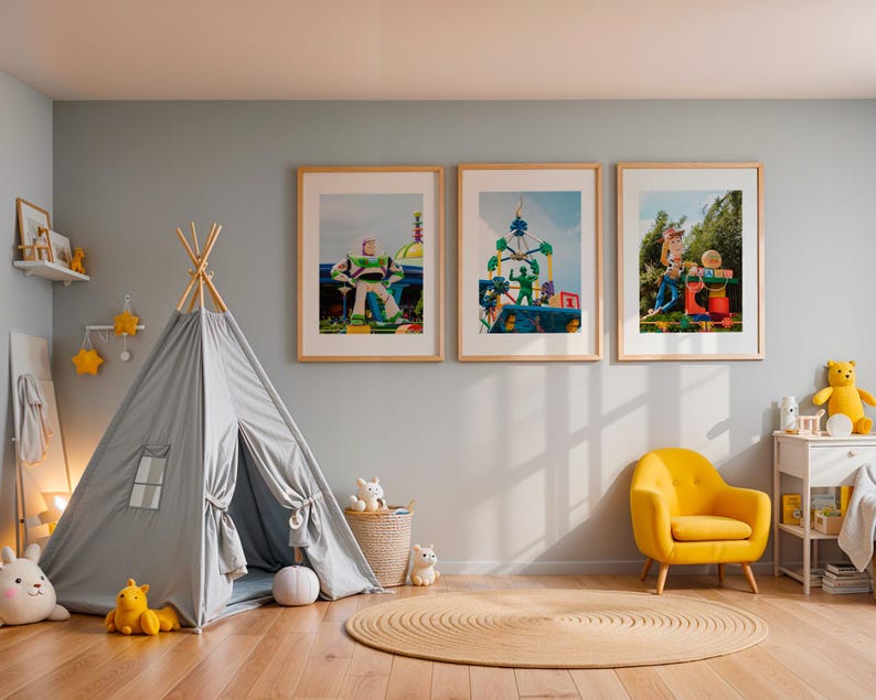 Puede incluir: Una tienda de campa&ntilde;a tipi gris con una ventana y una estrella amarilla colgando encima. Hay tres cuadros enmarcados en la pared detr&aacute;s del tipi, cada uno representando una escena colorida con un personaje de juguete. Un sill&oacute;n amarillo se encuentra frente al tipi, y una mesa peque&ntilde;a con un animal de peluche y juguetes est&aacute; en la esquina.