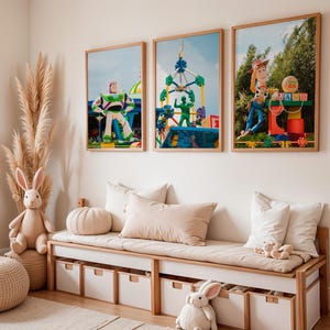 Puede incluir: Tres impresiones enmarcadas de personajes de Toy Story en una sala de juegos para ni&ntilde;os. Las impresiones representan a Woody, Buzz Lightyear y un paseo de carnaval. Las impresiones est&aacute;n colgadas en una pared blanca sobre un sof&aacute; beige con almohadas blancas.