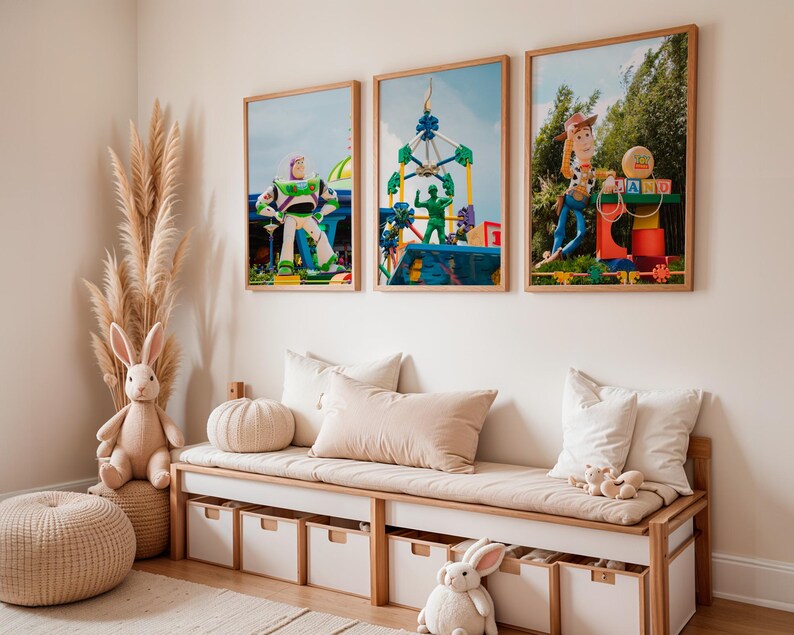 Puede incluir: Tres impresiones enmarcadas de personajes de Toy Story en una sala de juegos para ni&ntilde;os. Las impresiones representan a Woody, Buzz Lightyear y un paseo de carnaval. Las impresiones est&aacute;n colgadas en una pared blanca sobre un sof&aacute; beige con almohadas blancas.