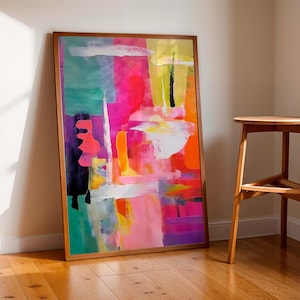 Puede incluir: Pintura abstracta en un marco de madera con colores brillantes como rosa, verde, amarillo y naranja. La pintura está en un suelo de madera frente a una pared blanca.