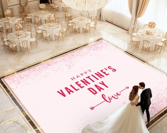 May include: A pink dance floor with a white background and pink confetti. The floor has the text "Happy Valentine's Day" and an arrow pointing to the right with the word "love" written above it. A bride and groom are standing on the dance floor.