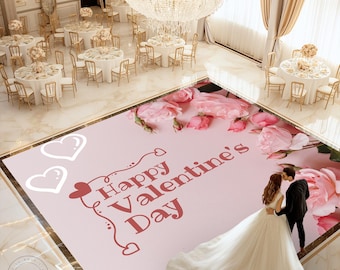 May include: A pink and white floor covering with the text "Happy Valentine's Day" in red. The floor covering features a floral design with pink roses and white hearts. A bride and groom are standing on the floor covering, the bride is wearing a white wedding dress and the groom is wearing a black suit.