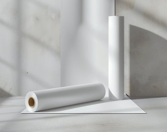 May include: Two white rolls of paper on a white surface. The rolls are lying flat and are in a studio setting.