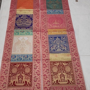 May include: Two decorative rectangular panels with a red floral border. Each panel features a series of colorful squares with elephant and peacock designs. The squares are in shades of orange, blue, green, and gold.