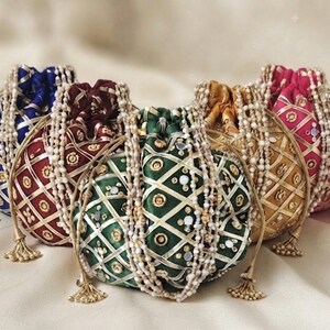 May include: Five drawstring pouches in blue, maroon, green, gold, and pink. Each pouch features a diamond-patterned overlay with metallic trim, small circular floral embroidery, and reflective accents. Long, multi-strand beaded handles are attached.