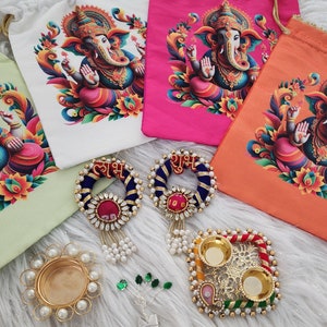 May include: An assortment of colorful drawstring bags featuring a vibrant illustration of the Hindu deity Ganesha. The image also includes decorative items such as beaded wreaths with text, a gold candle holder, and a silver tree.