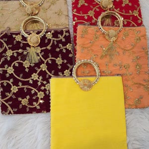 Puede incluir: Cinco peque&ntilde;os clutches bordados con asas de cuentas. Los clutches son de varios colores, incluyendo beige, rojo, granate, naranja y amarillo.
