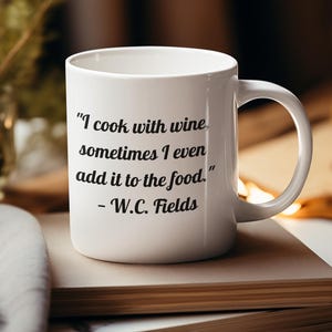 Puede incluir: Taza de cerámica blanca con una cita en negro que dice "Cocino con vino, a veces incluso lo añado a la comida." - W.C. Fields.
