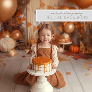 May include: A young girl in a brown dress holds a cake with a golden brown frosting. The cake is on a white cake stand. The background is a fall-themed backdrop with orange and brown tones.