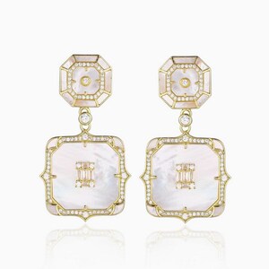 May include: A pair of gold earrings with a white mother-of-pearl design. The earrings feature a square shape with a smaller octagon shape at the top. The earrings are adorned with small diamonds.