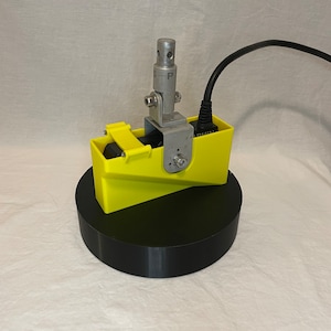 May include: A yellow and black device with a silver rod and a black cord. The device is labelled "GARMIN".