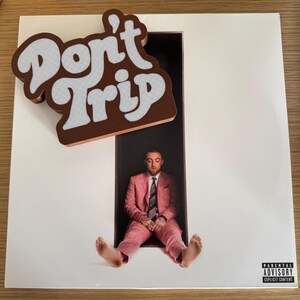 Pode incluir: Um &aacute;lbum de vinil com um &iacute;m&atilde; castanho e branco "Don't Trip" em cima. A capa do &aacute;lbum apresenta um homem de fato rosa. O &aacute;lbum tem um aviso para os pais.