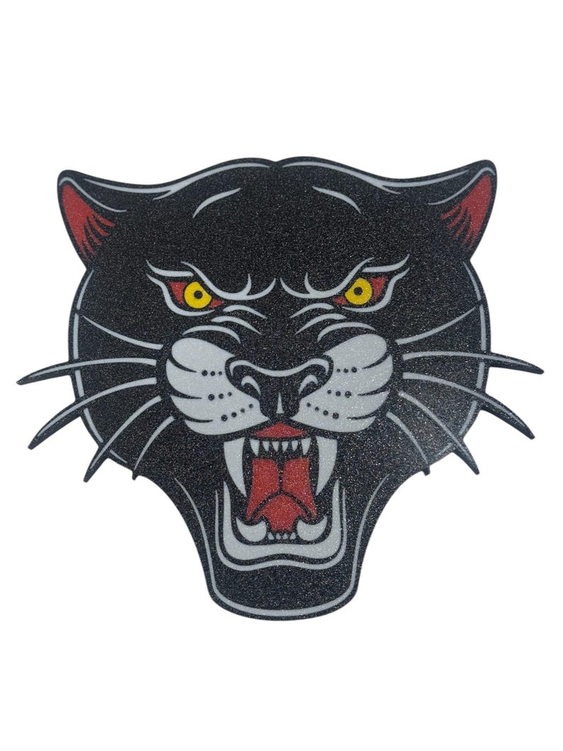 May include: A black panther head with a red mouth and yellow eyes. The panther is snarling with its teeth bared.