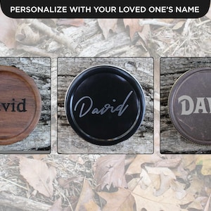 May include: Three round coasters, each engraved with the name "David". One is wooden, one black, and one grey. The text "Personalize with your loved one's name" is at the top. The coasters are for drinks.