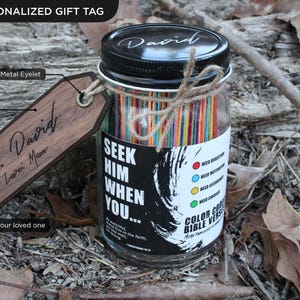 May include: A personalised gift jar with a black lid and a wooden tag. The jar contains colourful sticks and a label that reads "Seek Him When You..." The wooden tag is engraved with "To: David, I Love Mom."