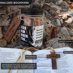 May include: A wooden cross pendant with the name "David" and a personalized bookmark rest on an open book. A glass jar filled with colourful paper strips and the text "Seek Him When You..." is also visible.