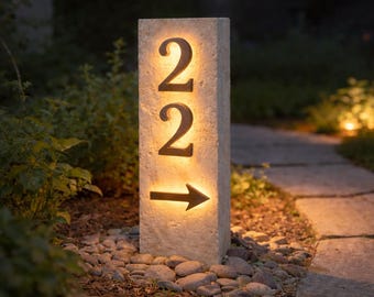 Dirección en piedra iluminada en esquina en forma de L con números de casa de acero.