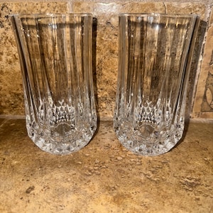 Może przedstawiać: Dwa przezroczyste szklane kieliszki do picia z diamentowym wzorem. Kieliszki są wysokie i smukłe.