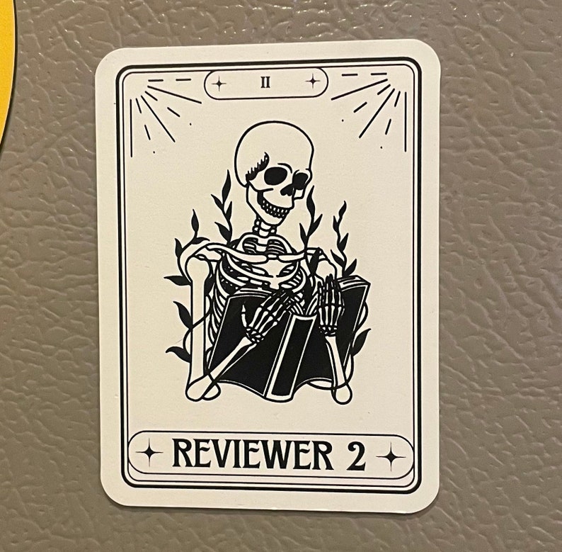May include: A black and white illustration of a skeleton reading a book. The illustration is on a white card with black text that says "REVIEWER 2" and "II".