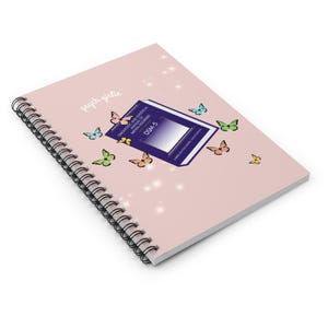 Puede incluir: Un cuaderno con espiral y tapa rosa claro. La portada presenta el texto "psych girlie" y un dise&ntilde;o que incluye un libro etiquetado como "DSM-5" y varias mariposas de colores. El cuaderno est&aacute; dise&ntilde;ado para tomar notas.