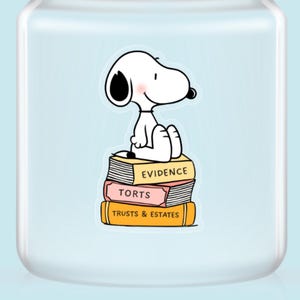 May include: A white cartoon dog sits atop a stack of books labeled "Evidence", "Torts", and "Trusts & Estates". The books are yellow and pink. The background is a light blue.