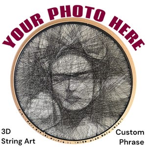 Könnte beinhalten: Rundes 3D-String-Art-Porträt mit Holzrahmen. Das Kunstwerk zeigt ein Gesicht, das mit schwarzem Faden erstellt wurde. Der Text oben lautet "YOUR PHOTO HERE", und unten "3D String Art" und "Custom Phrase".