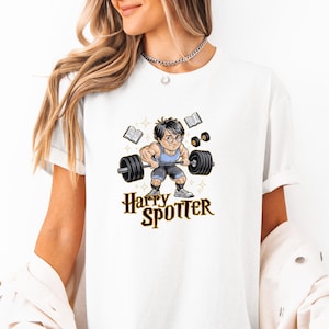 Pode incluir: Camiseta branca com um gráfico de Harry Potter levantando pesos. O gráfico diz "Harry Spotter" em letras douradas.