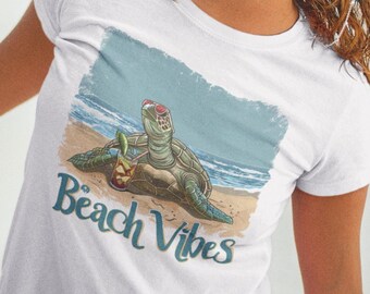 May include: White t-shirt featuring a graphic of a turtle wearing sunglasses and holding a tropical drink. The text "Beach Vibes" is printed below the turtle.