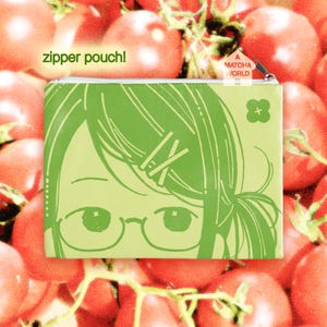Puede incluir: Un estuche con cremallera de color verde claro que presenta una ilustración de líneas de una persona con gafas y horquillas. El texto "zipper pouch!" está impreso en verde y una etiqueta en forma de casa dice "A MATCHA WORLD" cerca de la cremallera.