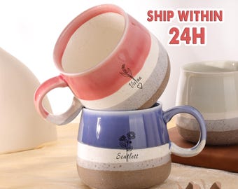 May include: A white ceramic mug with a black handle and the text "But First, Coffee" in a black, handwritten-style font. The mug is on a white surface.
