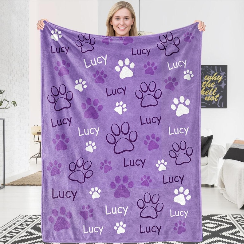 May include: Purple fleece blanket with a paw print pattern and the name "Lucy" repeated throughout.