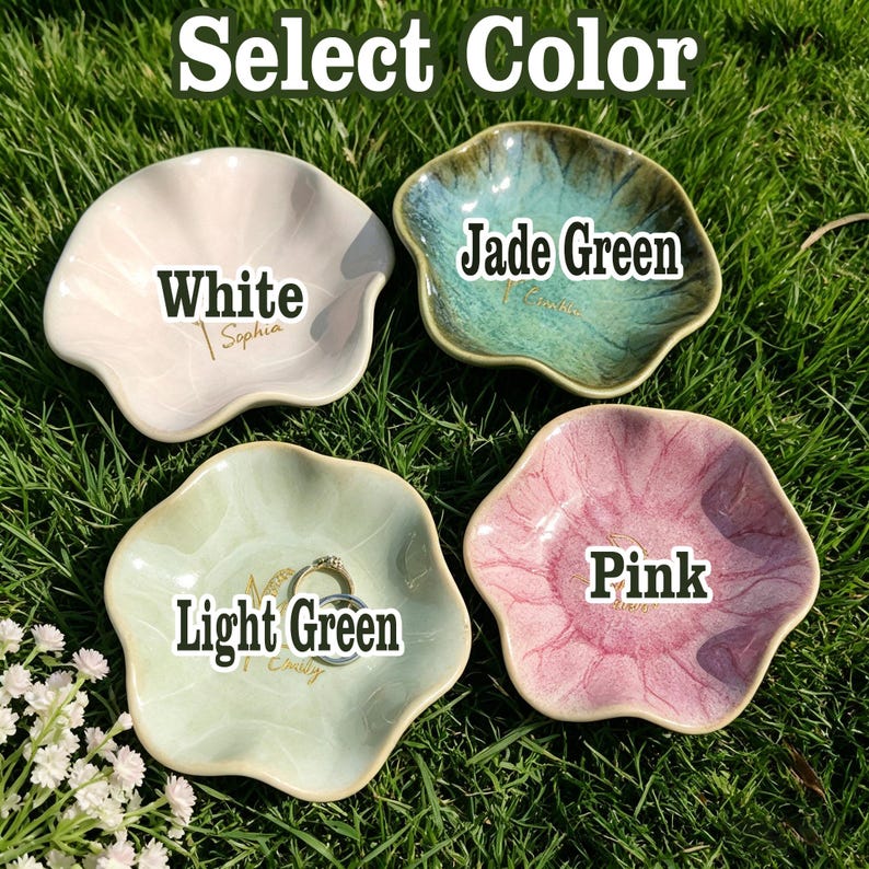 Puede incluir: Cuatro peque&ntilde;os platos de cer&aacute;mica con forma de flor en blanco, verde jade, verde claro y rosa. Cada plato tiene una etiqueta de color diferente: "Blanco", "Verde Jade", "Verde Claro" y "Rosa". Los platos est&aacute;n sobre un lecho de hierba verde.