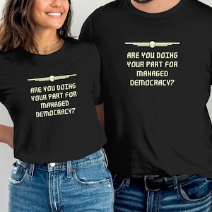 Puede incluir: Dos camisetas negras con una calavera blanca y el texto "Are you doing your part for managed democracy?"