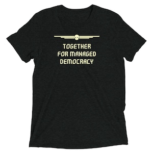 Può includere: T-shirt nera con un design grafico bianco che presenta un teschio con ali e il testo "TOGETHER FOR MANAGED DEMOCRACY".