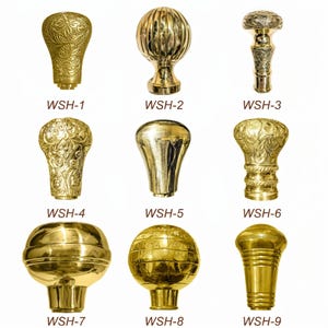 May include: A collection of nine polished brass walking stick handles labeled WSH-1 through WSH-9. The handles feature various shapes including spheres, tapered forms, and ornate floral engravings, with one spherical handle displaying a globe map design.